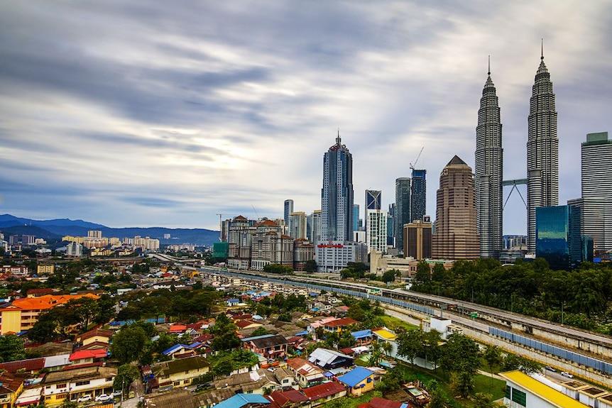 Traditional houses of Kampung Baru against the Kuala Lumpur skyline