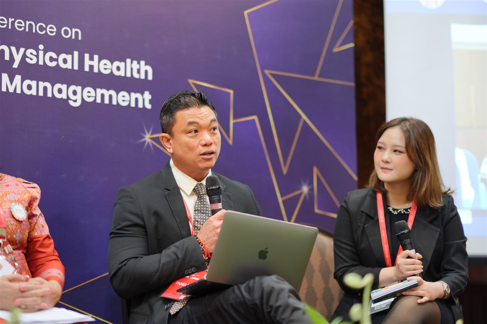 Panellists presenting with a laptop during a hybrid conference session